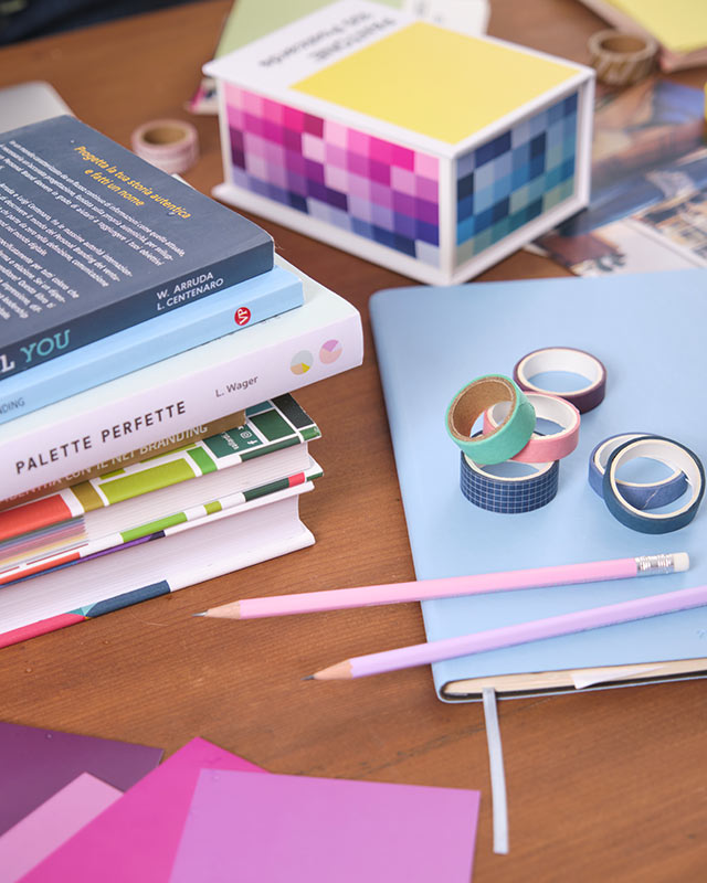 LAGRAFICALEGGERA_CARTOLERIA Particolare della scrivania con matite, agenza, washi tape, libri e carte pantone